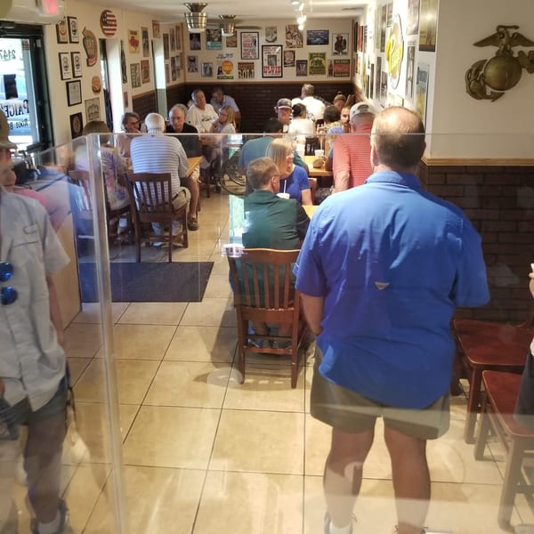 Diners seated at tables in Paige's Root Beer, a casual American restaurant with vintage decor.