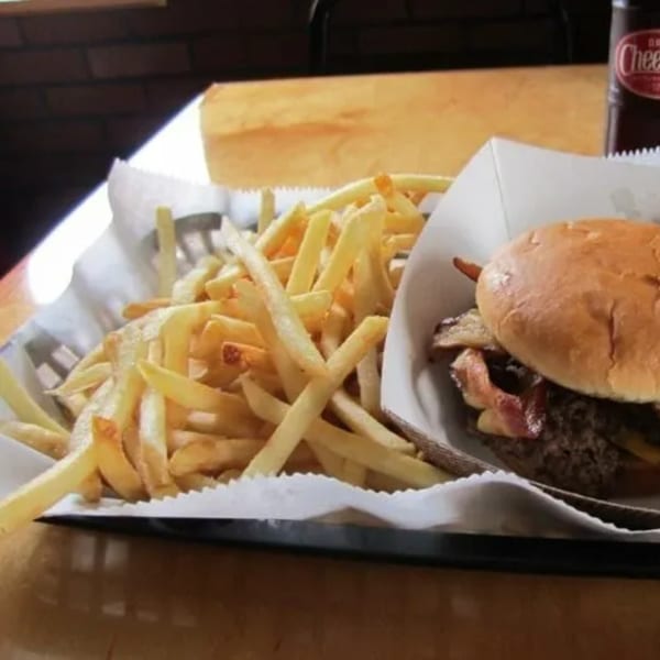 A Paige's Root Beer bacon cheeseburger and a basket of golden french fries.